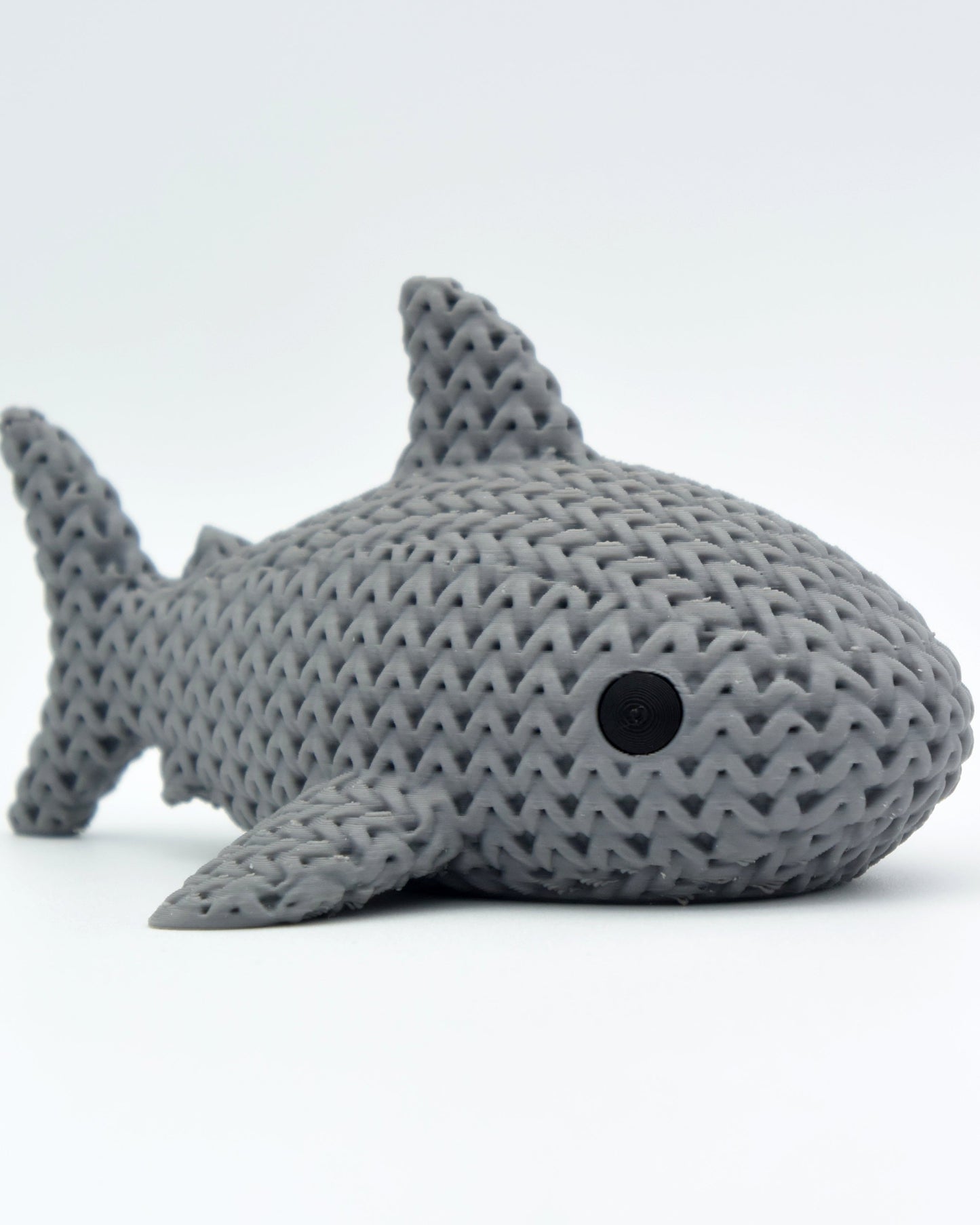 Close-up of a knitted shark figure with a soft crochet-look texture in light grey tones, 80mm long