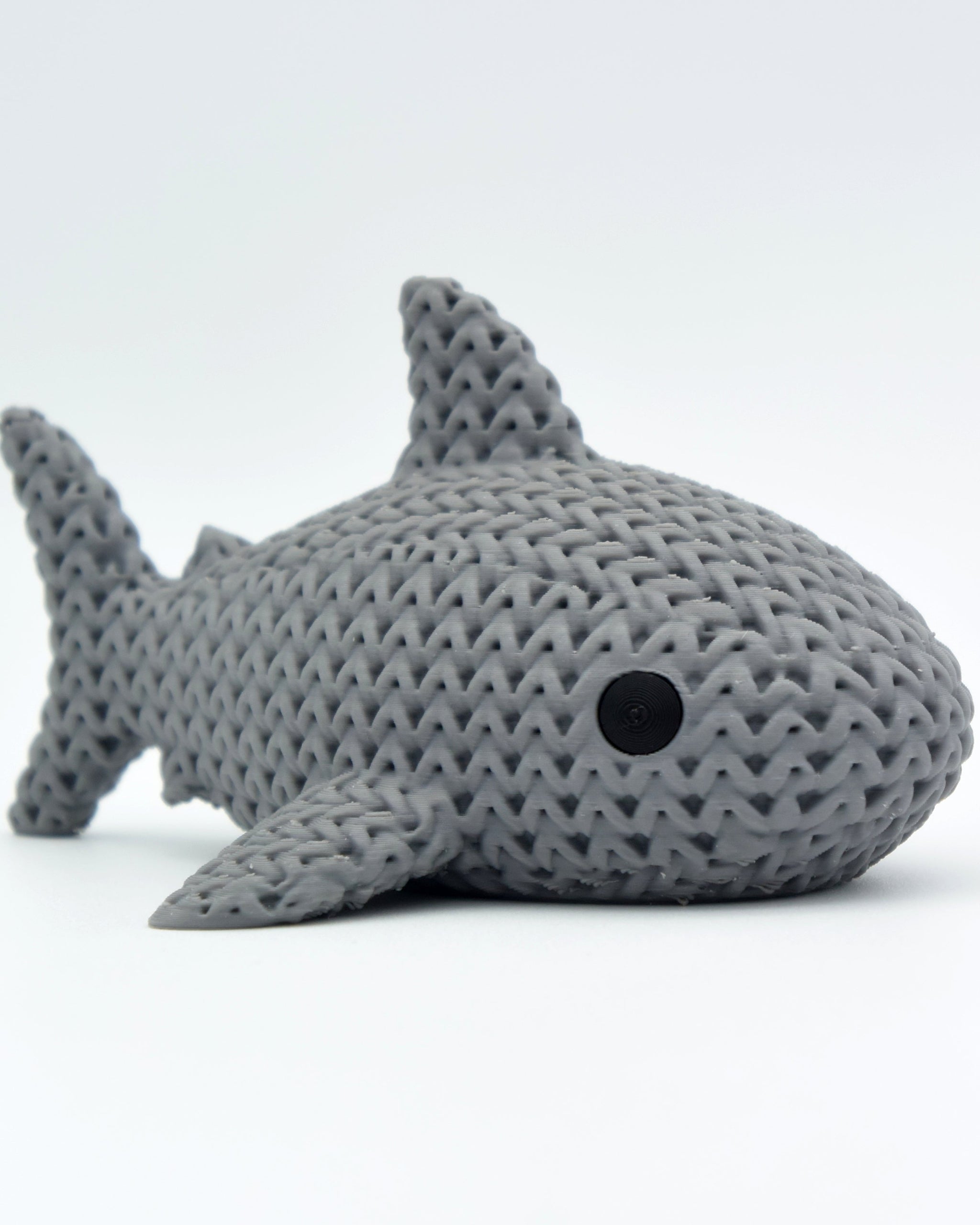 Close-up of a knitted shark figure with a soft crochet-look texture in light grey tones, 80mm long