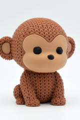 Close-up of a knitted monkey figurine with a detailed crochet-look texture, shown on a light surface