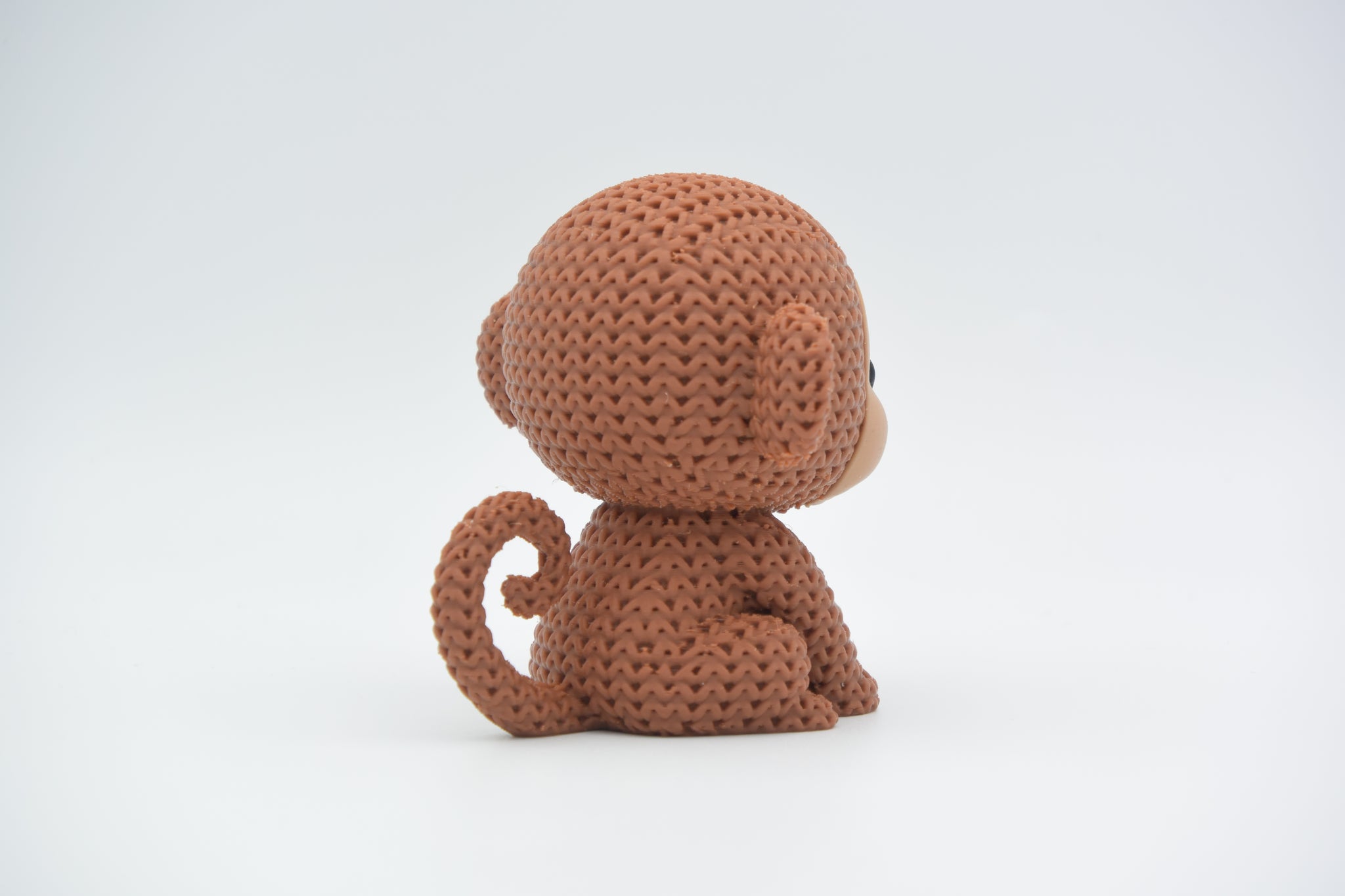 Texture detail of the knitted monkey showing the woven crochet-like pattern across the surface