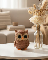 Close-up of a knitted owl decoration with a soft crochet-look texture, shown in warm terracotta colour