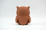 Detail shot of the textured surface of a knitted owl figurine showing the woven crochet-like pattern