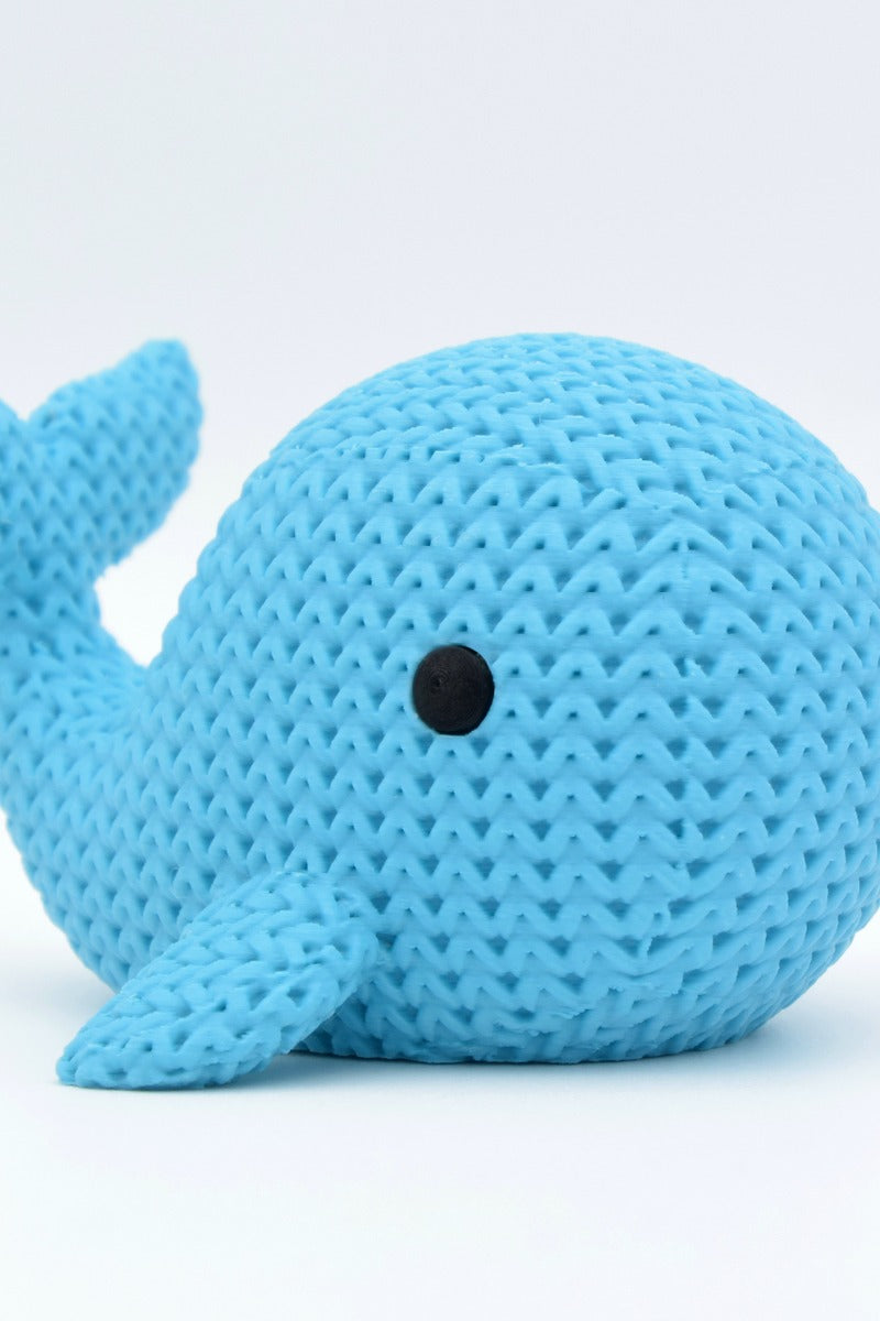 Close-up of a knitted whale figurine with a soft crochet-look texture and small detailed eyes, 49 DKK