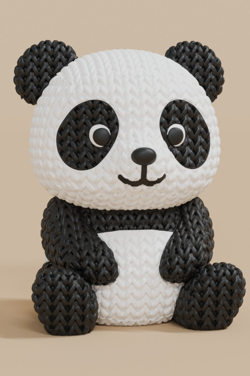 Close-up of a knitted panda figurine showing black and white crochet-look texture, small decorative object