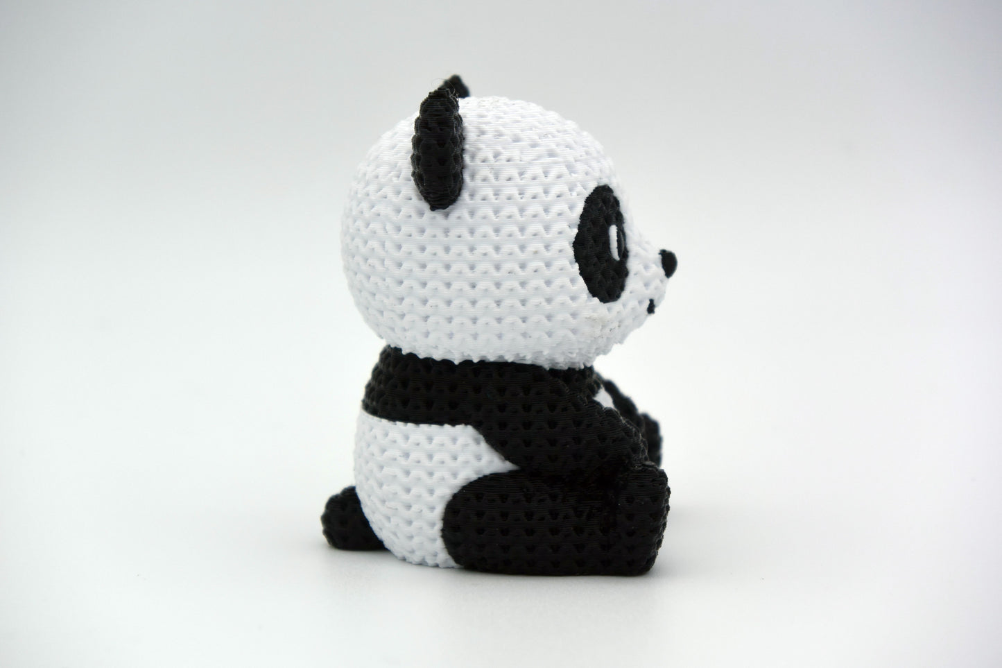 Detail shot of the knitted panda surface texture showing the soft, woven stitch pattern in black and white
