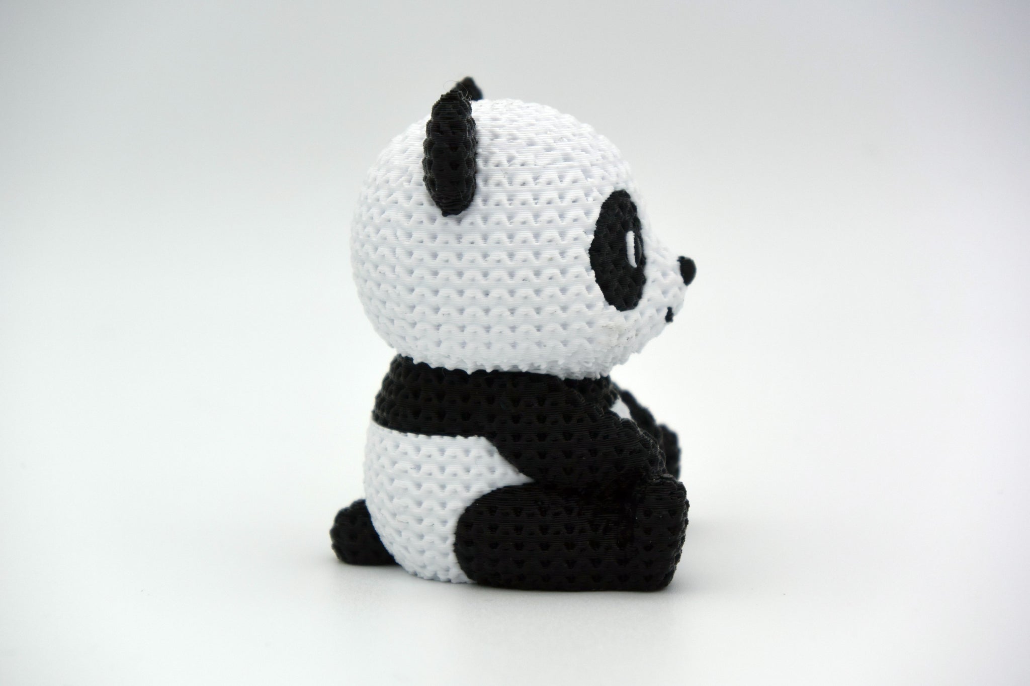 Detail shot of the knitted panda surface texture showing the soft, woven stitch pattern in black and white