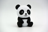 Close-up of a knitted panda figurine showing black and white crochet-look texture, small decorative object