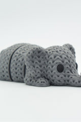 Close-up of a knitted elephant keychain with textured crochet-like surface and articulated body segments