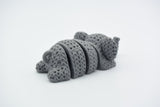 Detail shot of the flexible jointed segments on a knitted elephant keychain showing woven texture