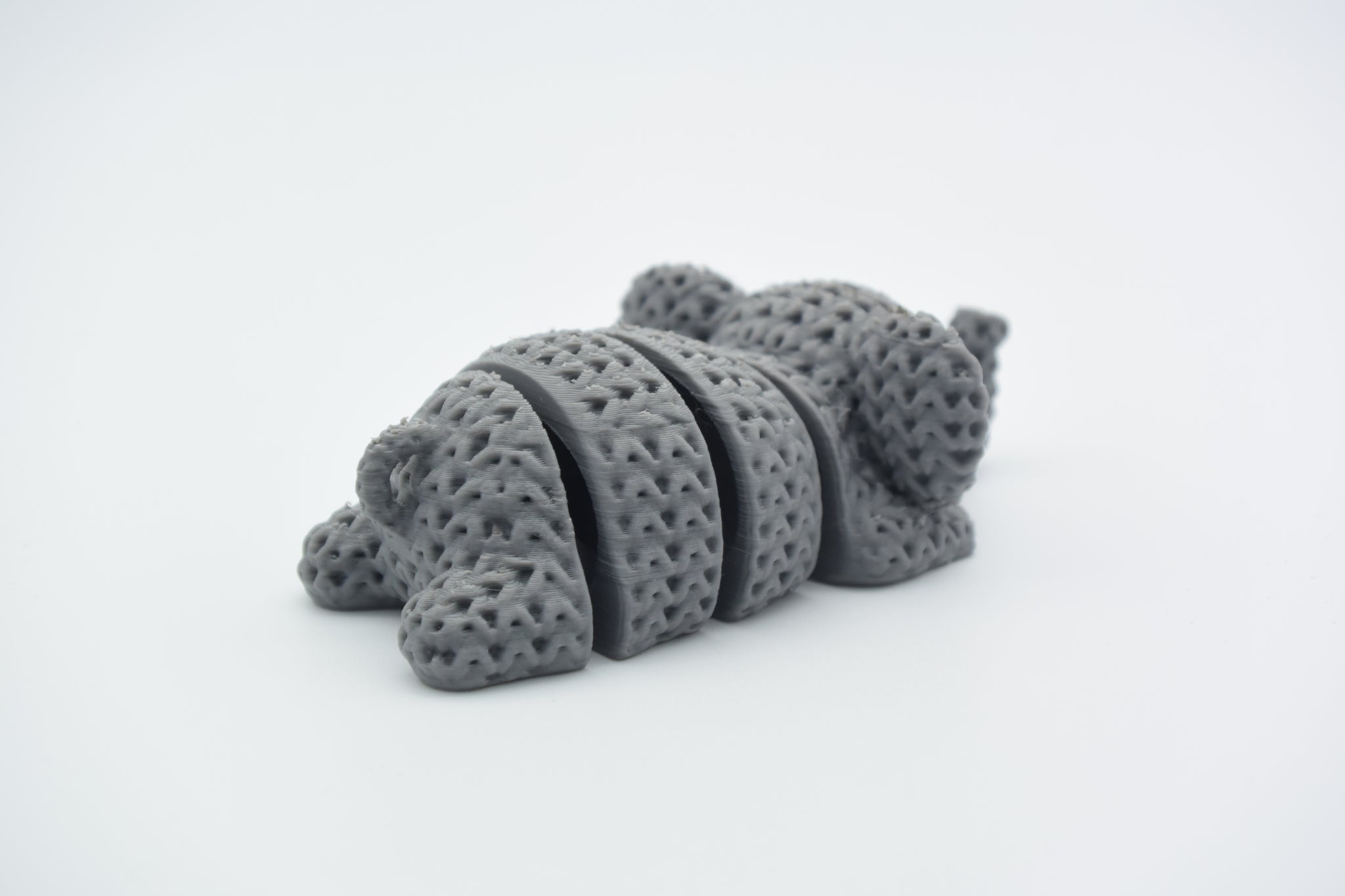 Detail shot of the flexible jointed segments on a knitted elephant keychain showing woven texture