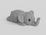 Close-up of a knitted elephant keychain with textured crochet-like surface and articulated body segments