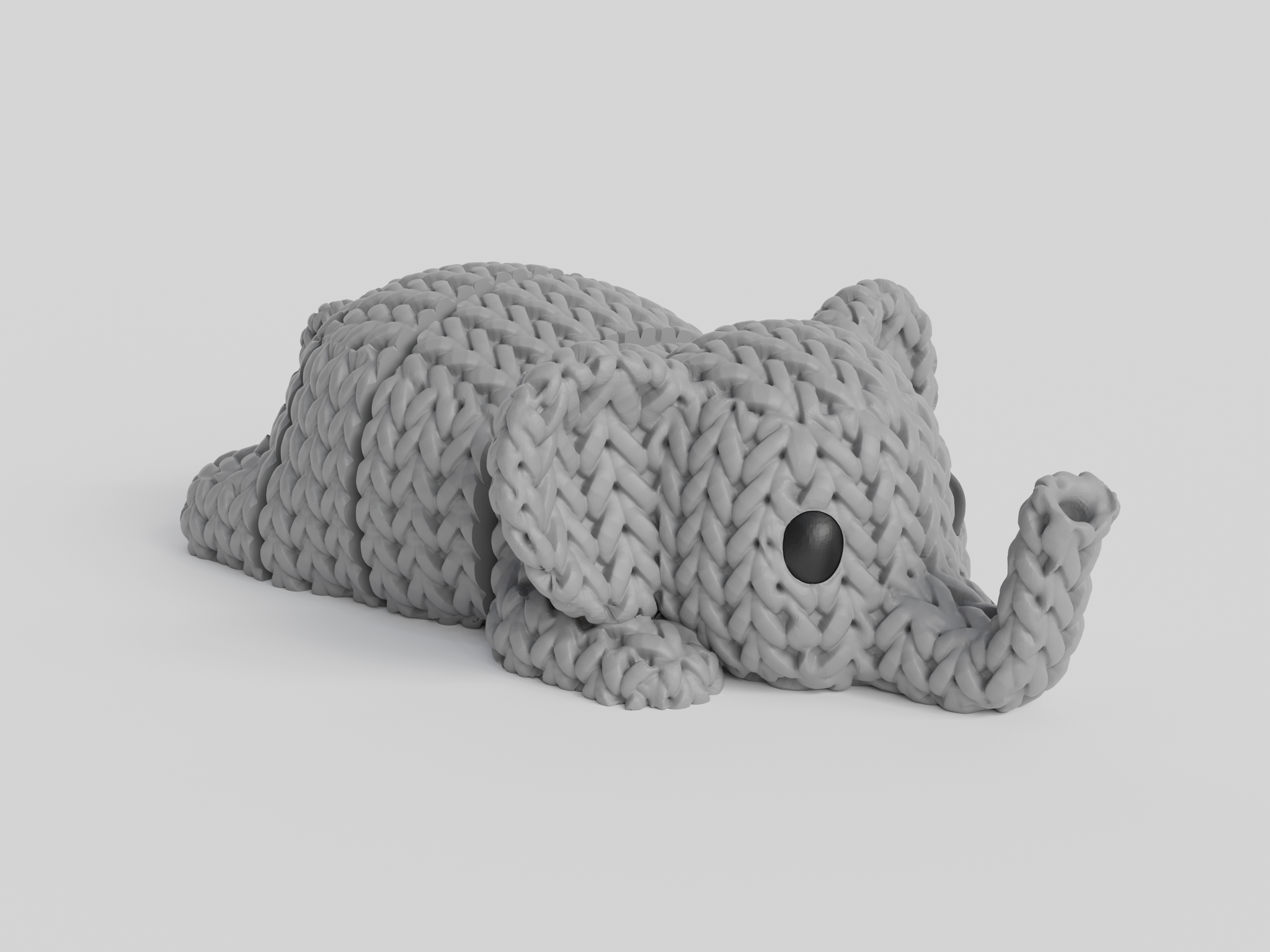 Close-up of a knitted elephant keychain with textured crochet-like surface and articulated body segments