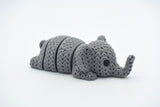 Close-up of a knitted elephant keychain with textured crochet-like surface and articulated body segments