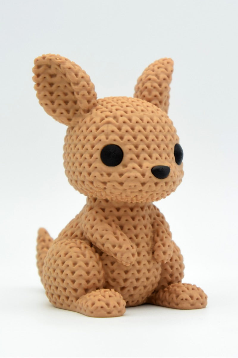 Close-up of a knitted kangaroo figurine with detailed crochet-loop texture, shown in warm neutral tones