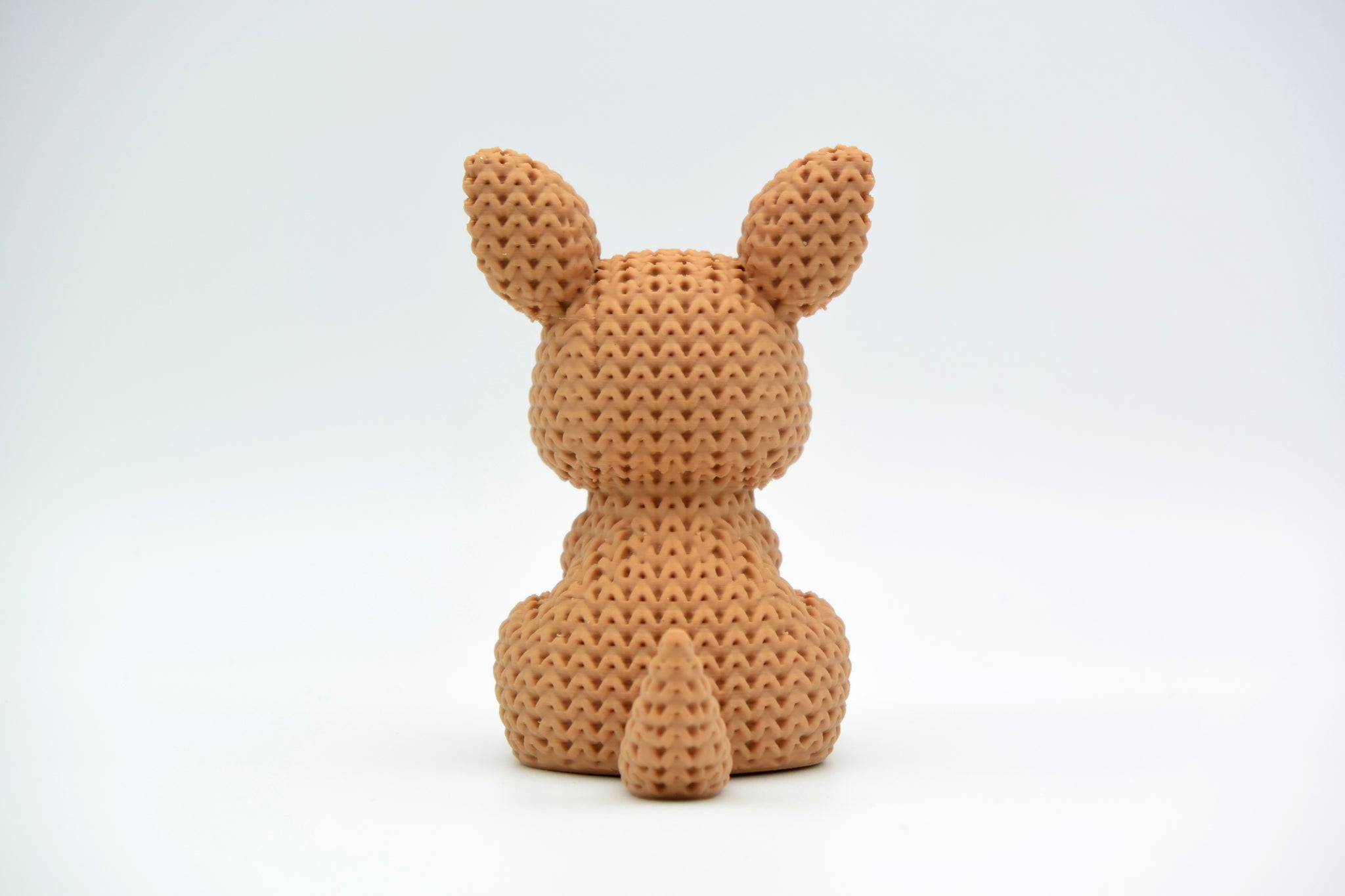 Macro detail of the crochet-look surface texture on a knitted kangaroo figurine, showing soft looped pattern