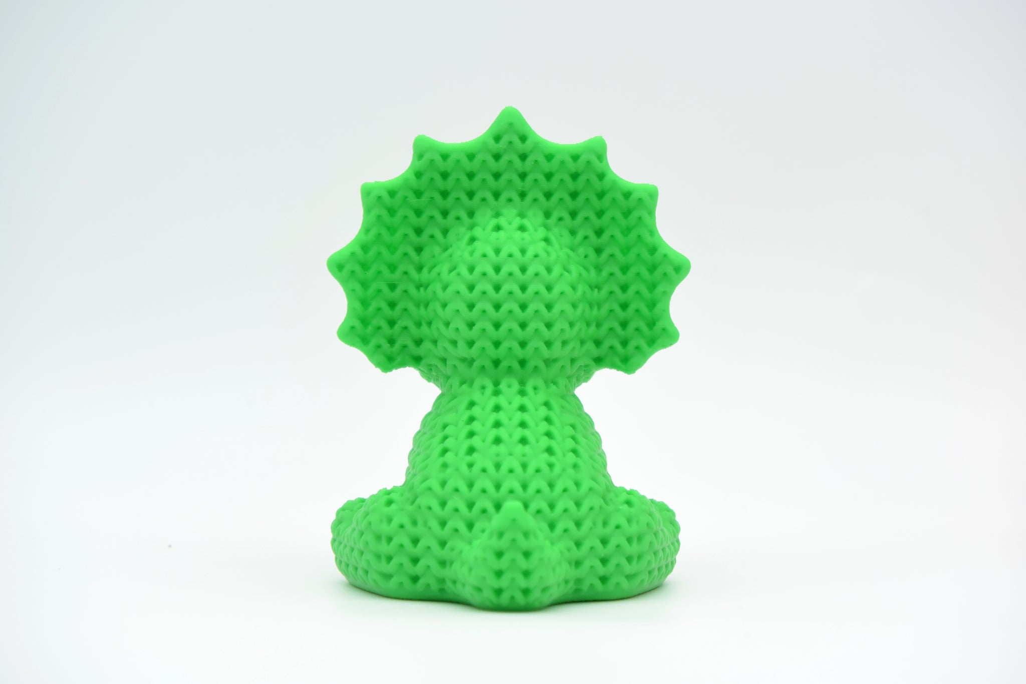 Close-up of a knitted triceratops figurine with textured crochet surface and three horns, 49 DKK