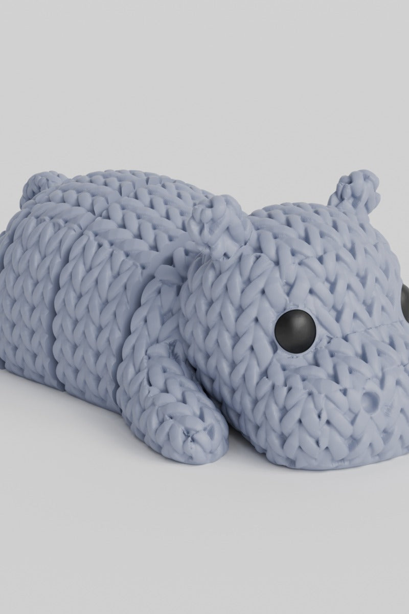 Close-up of a knitted hippo figurine with textured crochet-look surface, photographed on a white background