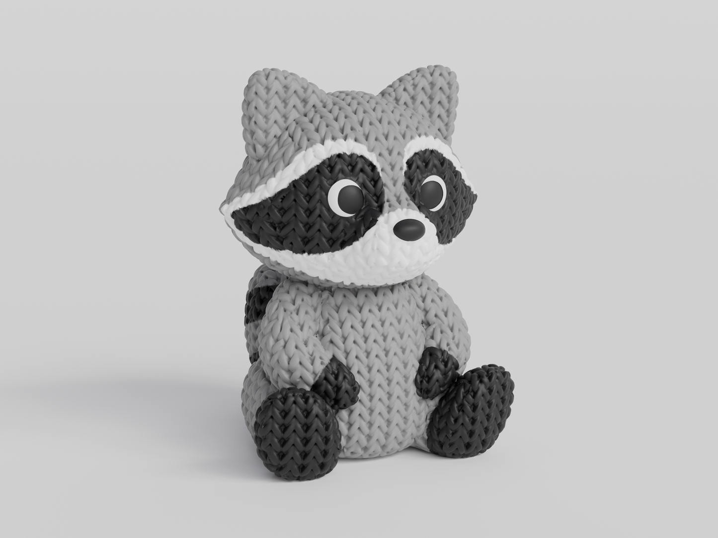 Close-up of a knitted raccoon figurine with a detailed crochet-look texture, shown against a white background