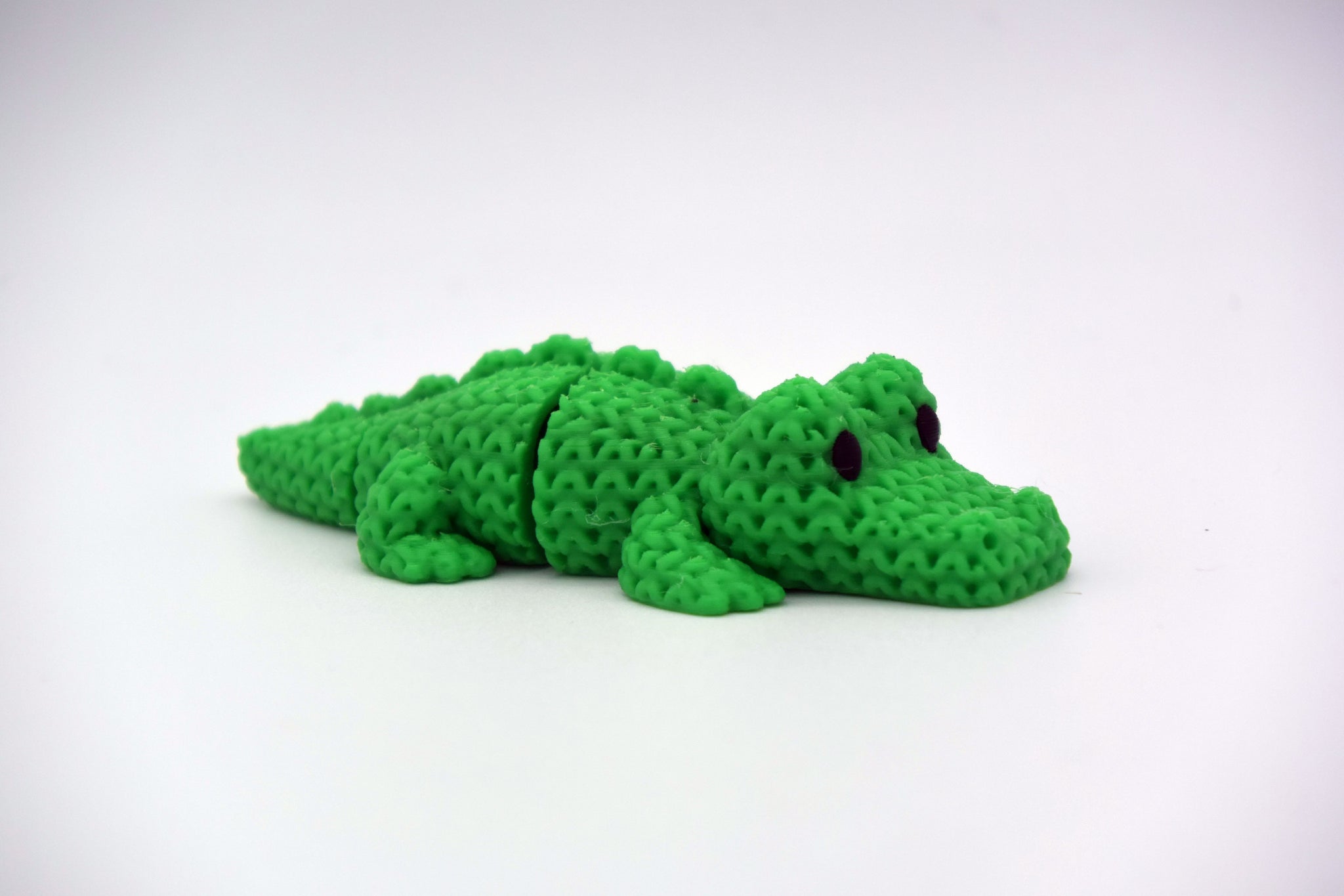 Close-up of a knitted crocodile with textured crochet-look scales and flexible segmented body, 49 DKK