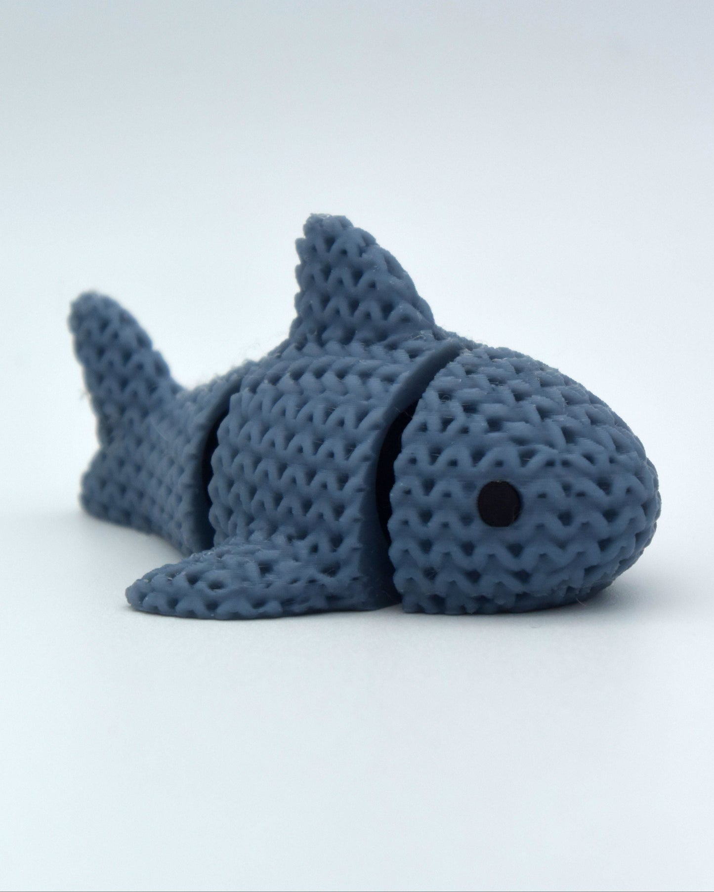 Texture detail of the knitted shark surface showing individual woven segments along its body