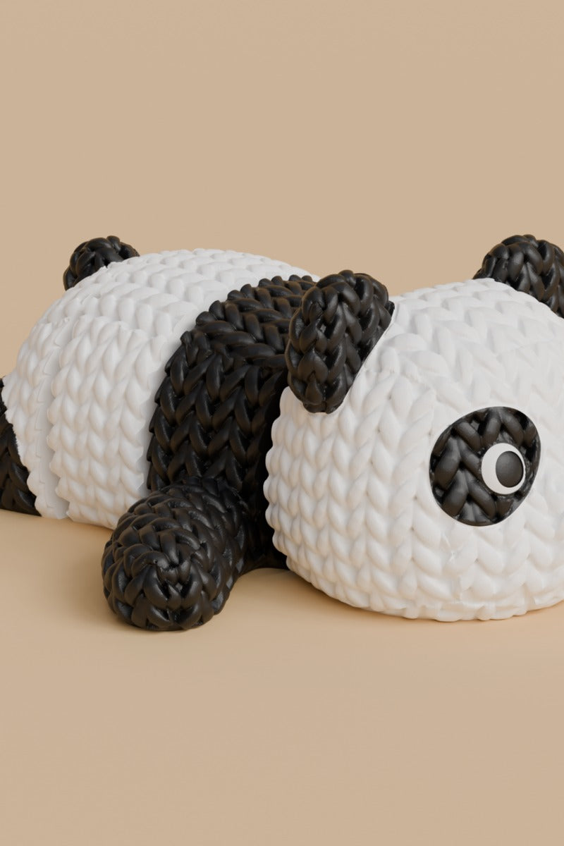 Knitted articulated panda figure in black and white with crochet-look texture, full body close-up on white background