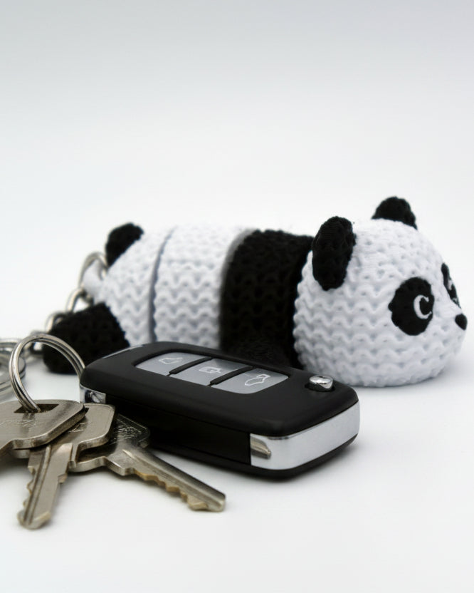 Close-up of the knitted panda texture detail showing the woven black and white surface pattern on its back