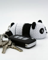 Close-up of the knitted panda texture detail showing the woven black and white surface pattern on its back