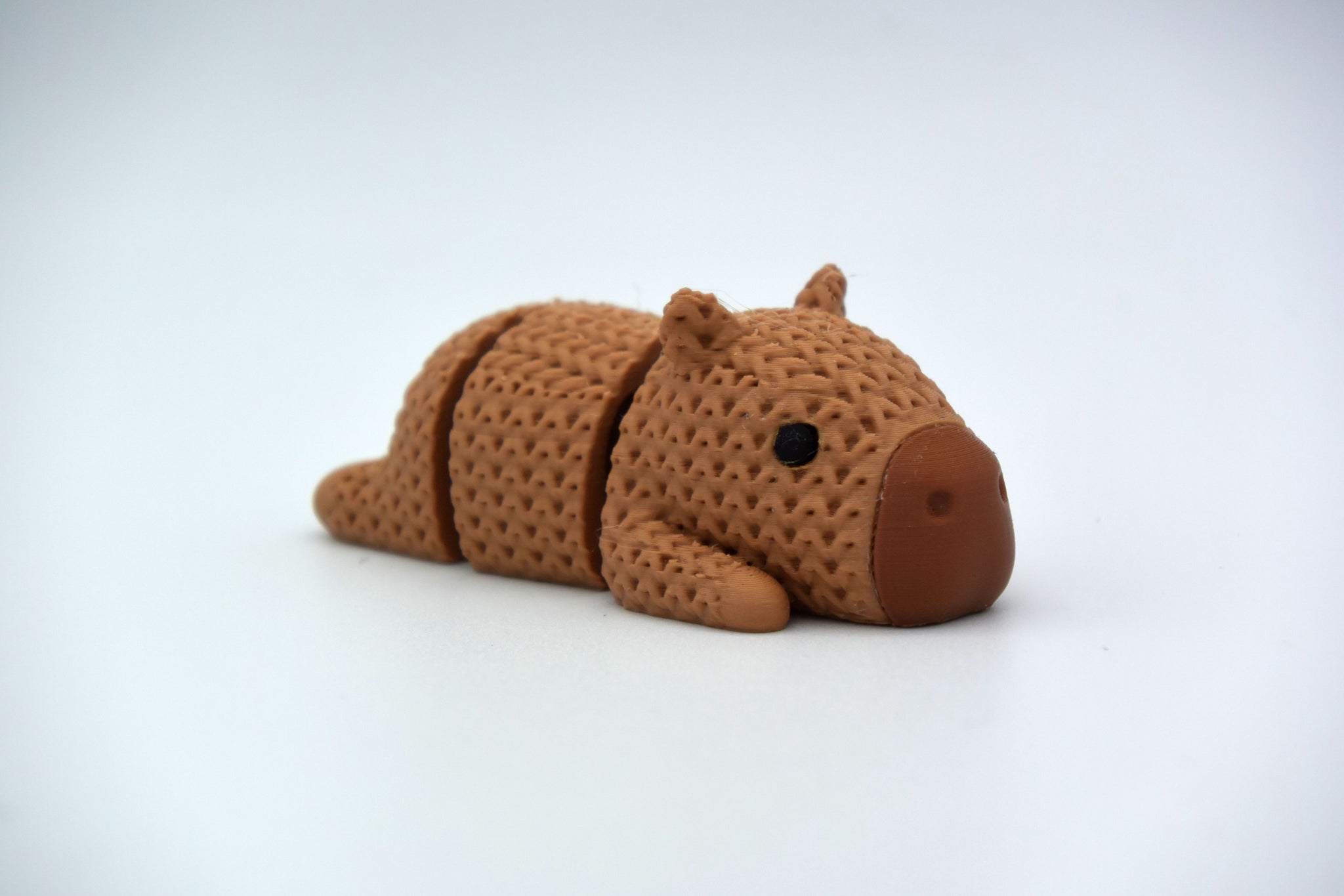 Detail shot of the woven knit-look texture on the back of a decorative capybara figurine in warm brown tones