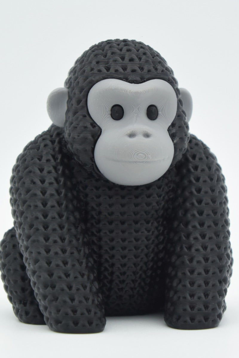 Close-up of a knitted gorilla figurine with detailed crochet-texture surface, photographed on a light background