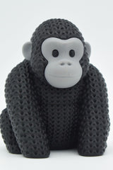 Close-up of a knitted gorilla figurine with detailed crochet-texture surface, photographed on a light background