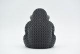 Close-up of a knitted gorilla figurine with detailed crochet-texture surface, photographed on a light background