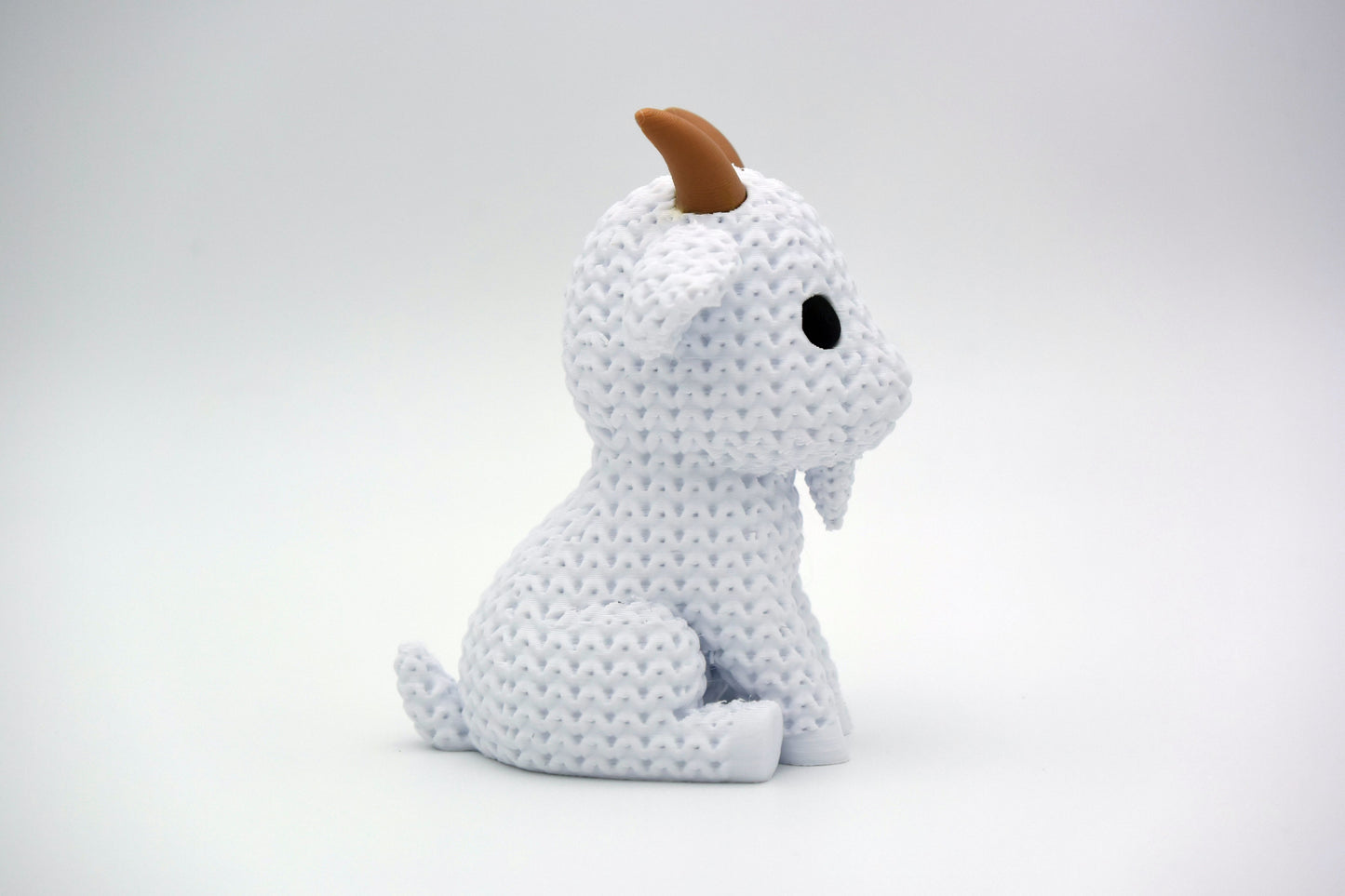 Texture detail of the knitted goat showing the fine loop pattern across the body surface