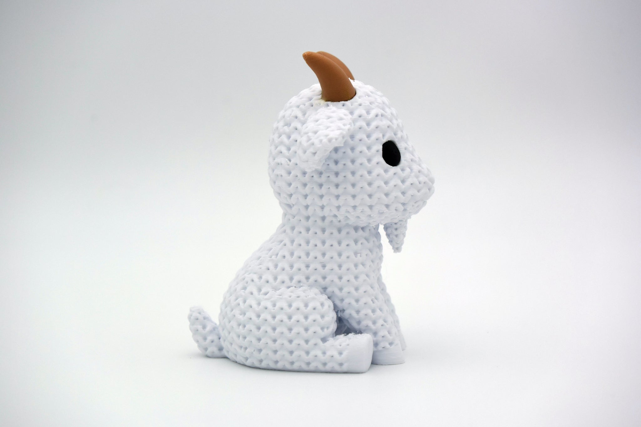 Texture detail of the knitted goat showing the fine loop pattern across the body surface