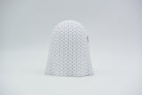 Knitted Halloween ghost glowing softly on a wooden shelf with autumn leaves and a candle beside it