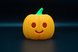 Texture detail of knitted halloween pumpkin surface showing woven pattern and carved facial features