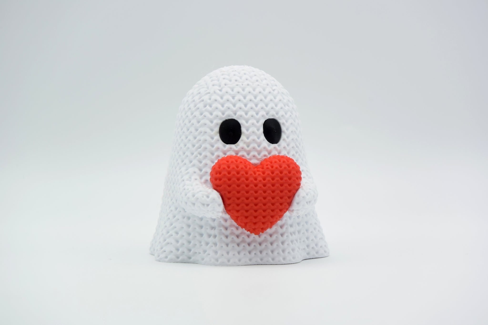 Close-up of a knitted ghost decoration with a heart detail, soft crochet texture in white and red, 49 DKK