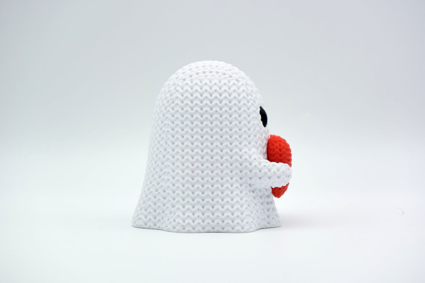 Close-up of a knitted ghost decoration with a heart detail, soft crochet texture in white and red, 49 DKK