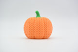 Detail of the knitted surface texture on a crochet pumpkin decoration showing soft ribbed pattern and rounded form