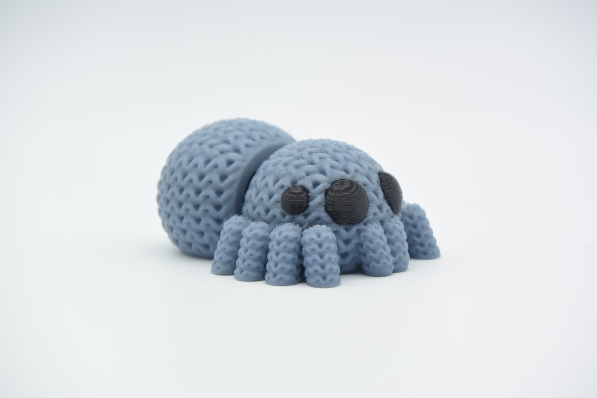 Detail shot of the soft knitted texture on a flexible spider decoration leg, showing crochet-like pattern