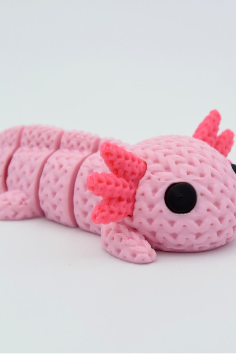 Close-up of a knitted axolotl figure with textured crochet-like surface and soft pink colouring, 49 DKK