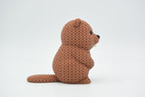 Small knitted beaver decoration styled on a wooden shelf beside plants in a Scandinavian living room