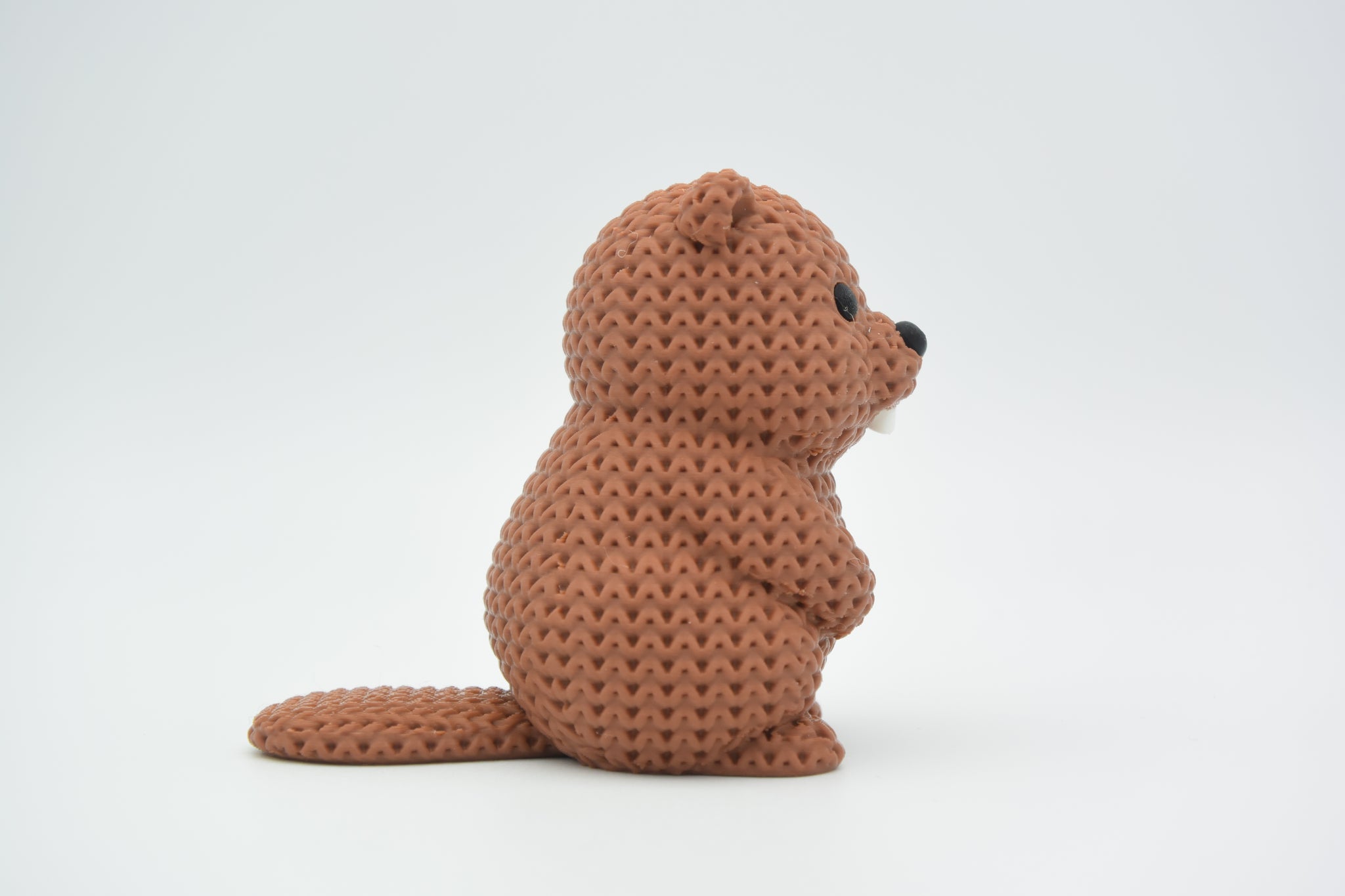 Small knitted beaver decoration styled on a wooden shelf beside plants in a Scandinavian living room
