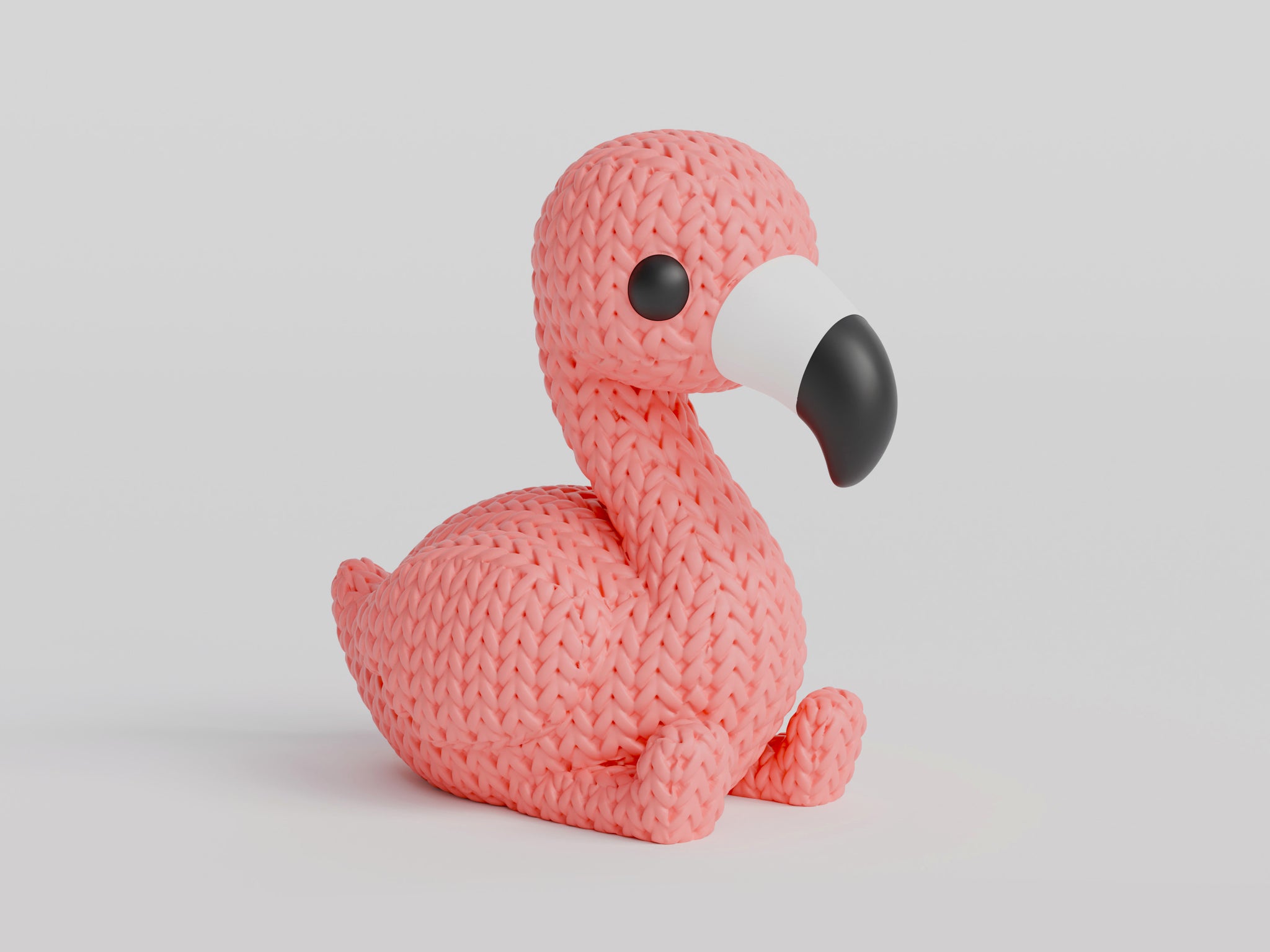 Close-up of a pink knitted flamingo figurine with a soft crochet-look surface texture, standing upright