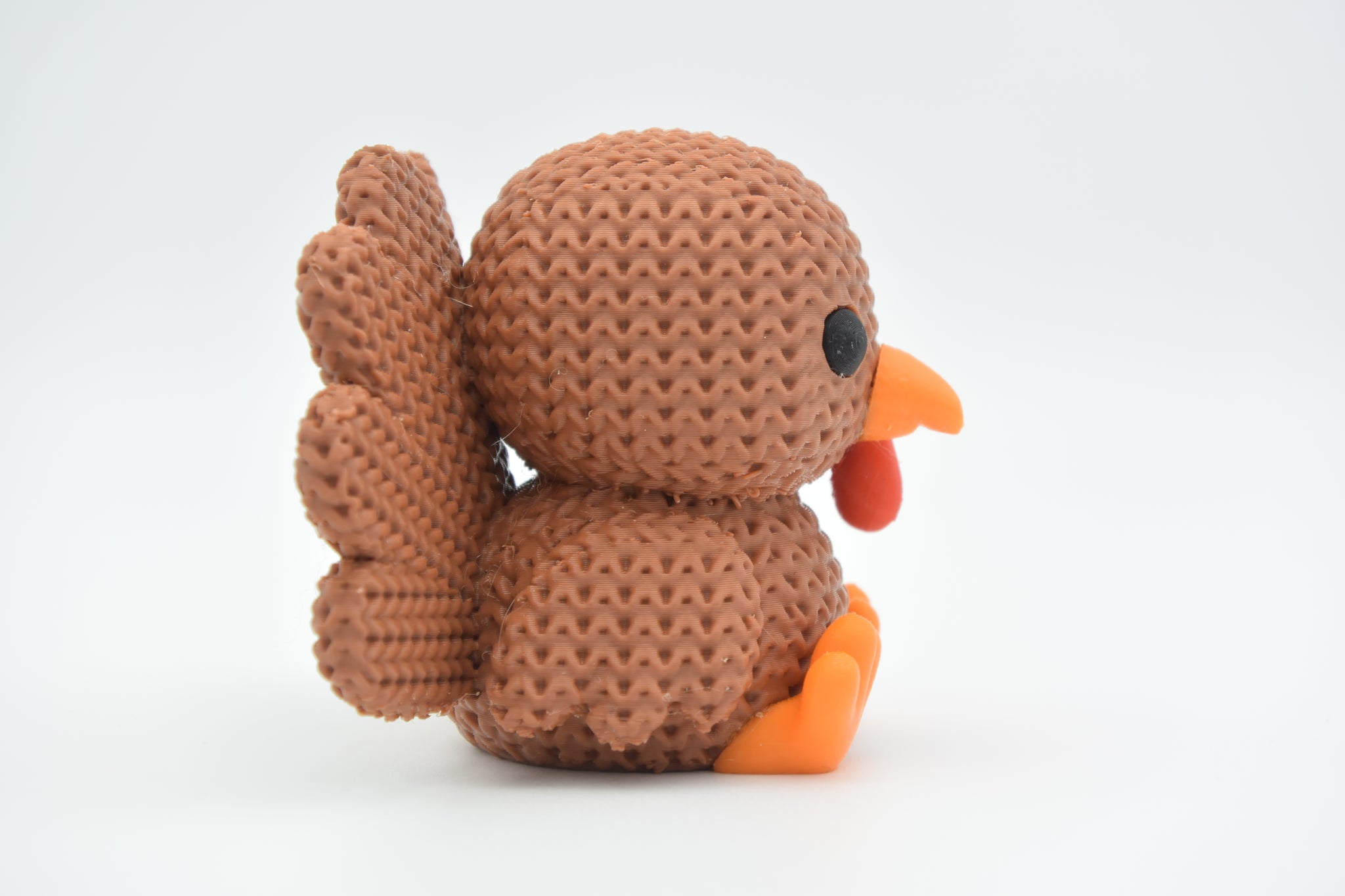 Knitted turkey decoration styled on a wooden autumn table with candles and dried leaves
