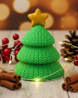 Close-up of a knitted Christmas tree decoration with open crochet-look texture and a small star topper