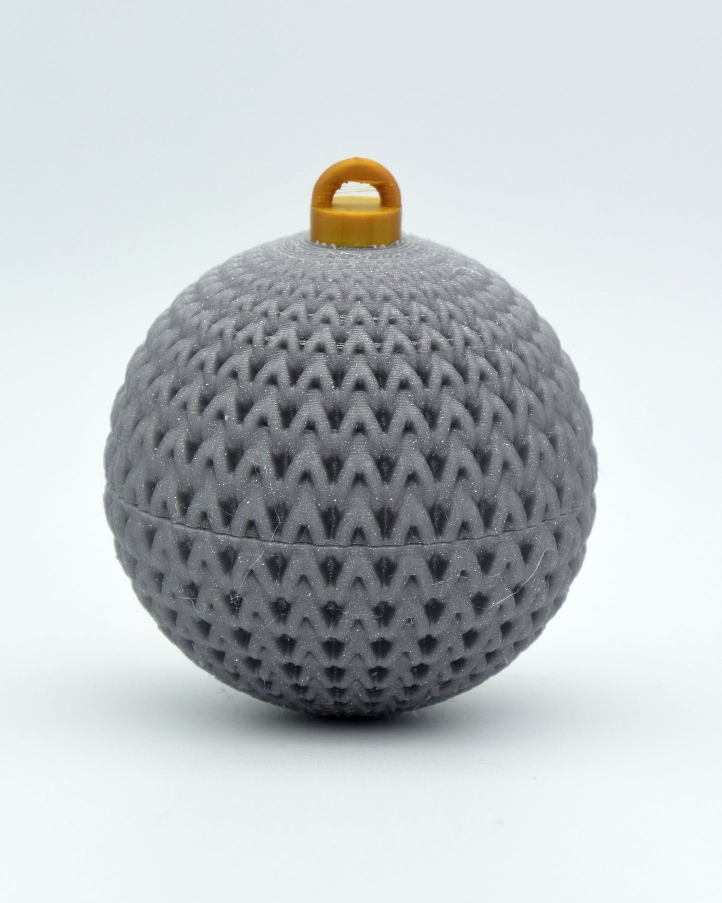Knitted Christmas ornament hanging on a decorated Christmas tree with warm ambient lighting