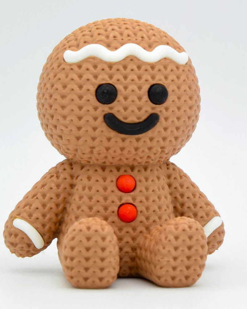 Close-up of a knitted gingerbread man decoration with white icing detail and soft woven texture, 49 DKK