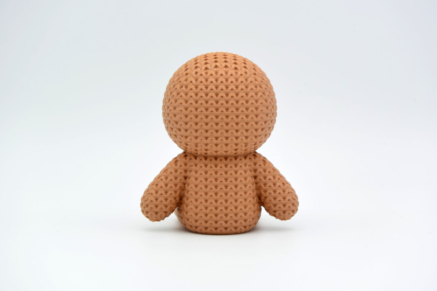 Texture detail of the knitted gingerbread man showing the soft crochet-like surface and icing smile