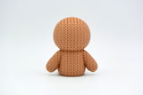 Texture detail of the knitted gingerbread man showing the soft crochet-like surface and icing smile