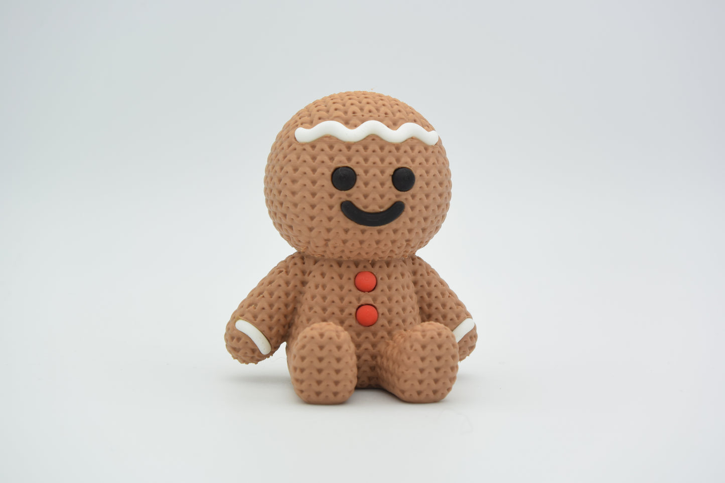 Close-up of a knitted gingerbread man decoration with white icing detail and soft woven texture, 49 DKK